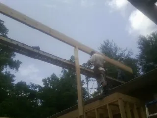 Carpenter setting a ridge beam over a new addition frame — Ice Dam Removal by Roofing Brothers in Greeneville