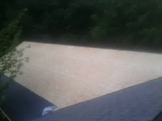 New OSB roof sheathing installed beside an existing shingle roof in Greeneville