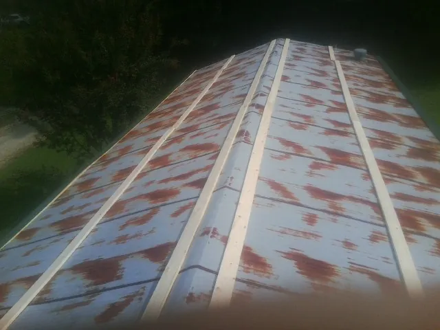 Rusted metal roof panels with new wood purlins before replacement — Storm Damage Roof Repair in Greeneville by Roofing Brothers