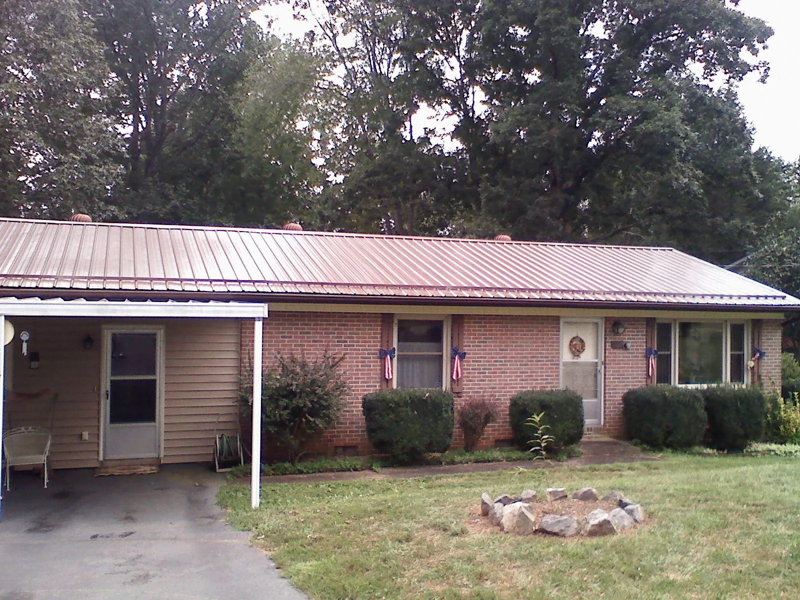 Bronze metal roof and carport on a brick ranch home — Roof Repair work by our crew in Greeneville