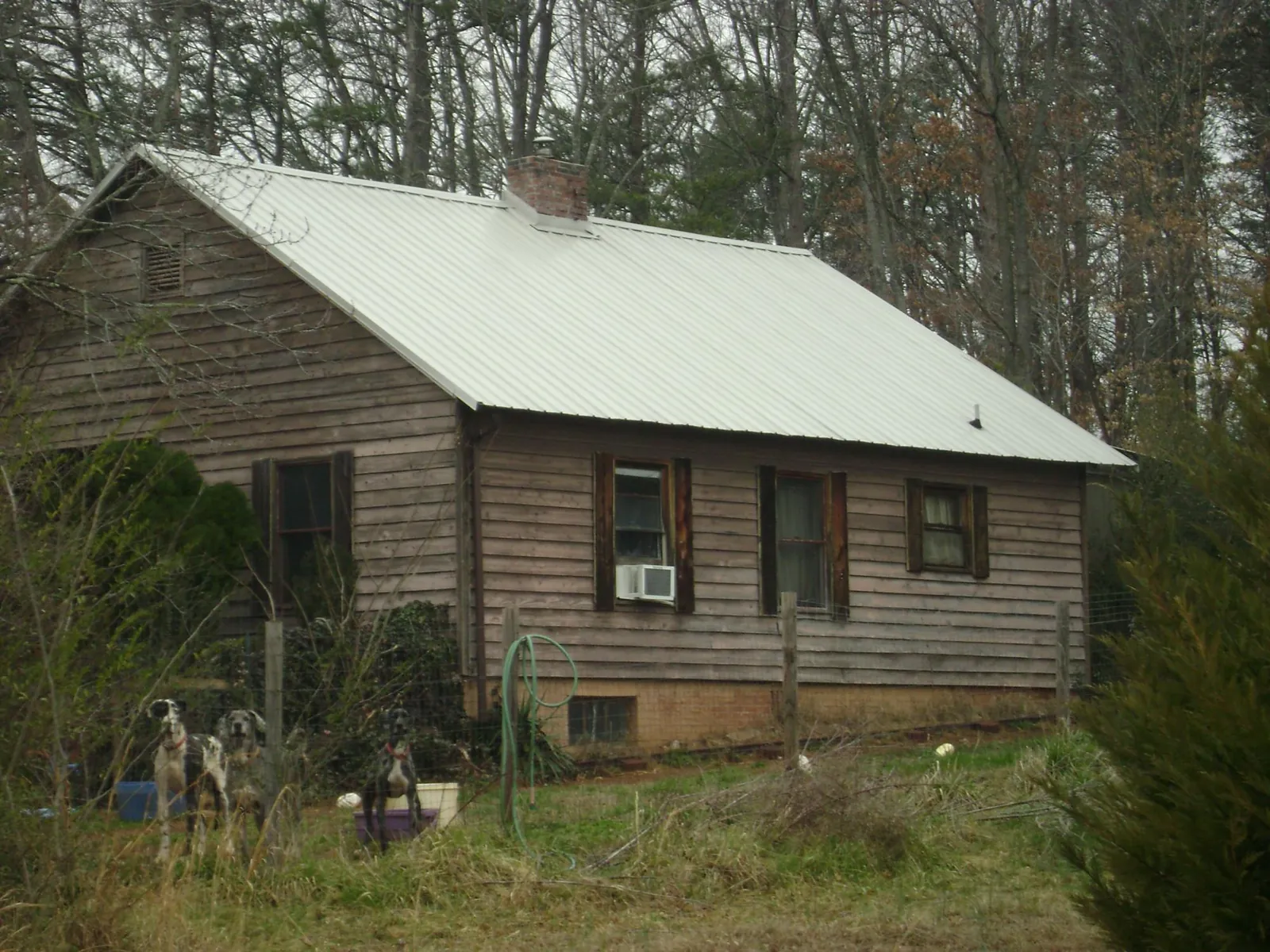 White metal roof on an old wood sided farmhouse, from a Metal Roof Installation job in Greeneville